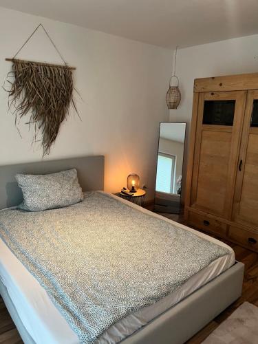 een slaapkamer met een bed, een dressoir en een spiegel bij Ferienvermietung Schneider in Wiehl