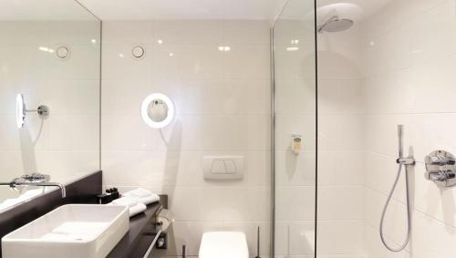 a bathroom with a shower and a sink and a toilet at Van der Valk Hotel Hildesheim in Hildesheim