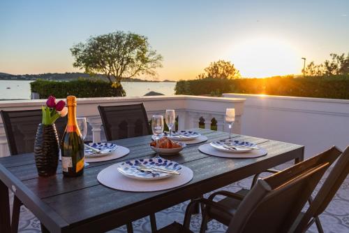 einen Holztisch mit Teller mit Speisen und Weinflaschen in der Unterkunft At grandpa's in Srima