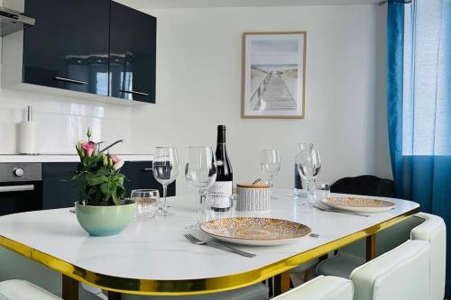 a dining room table with plates and wine glasses at Duplex Chez Caro, 180m de la mer à Cayeux sur mer in Cayeux-sur-Mer