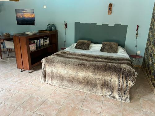 1 dormitorio con 1 cama con manta peluda en La Pierre rouge, en Floressas