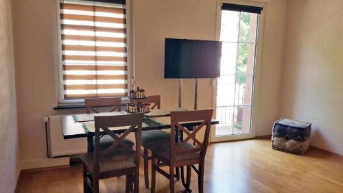 a dining room with a table and chairs and windows at Gästehaus Luise in Bad Bergzabern