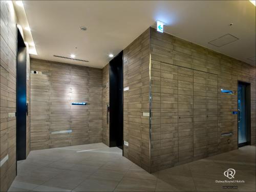 a hallway with a large wall of wood at Daiwa Roynet Hotel Chiba Ekimae in Chiba
