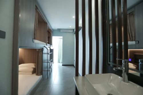 bagno con letto, lavandino e specchio di Yunbo Youth Hostel Ürümqi a Ürümqi