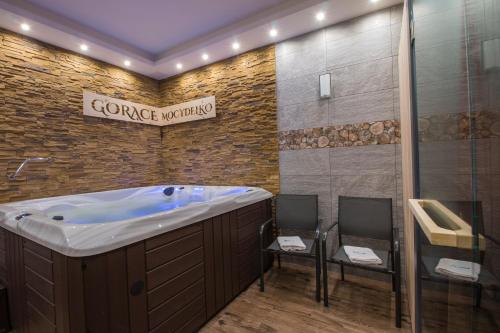 a bathroom with a large tub and two chairs at Dom Wypoczynkowy U Staszla in Bańska