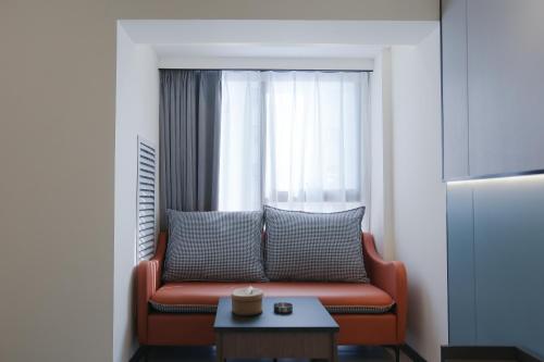 a living room with a couch in front of a window at Yunbo Youth Hostel Ürümqi in Ürümqi