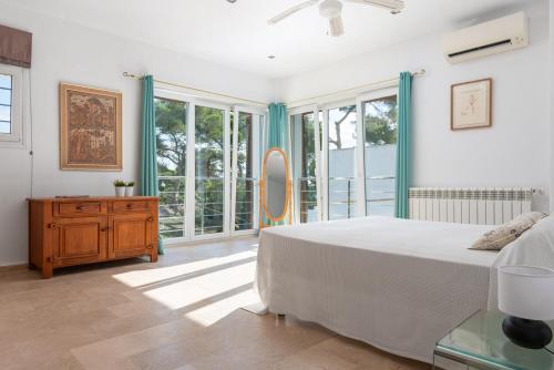 a bedroom with a bed and a large window at Casa Ramon in Cala d´Or