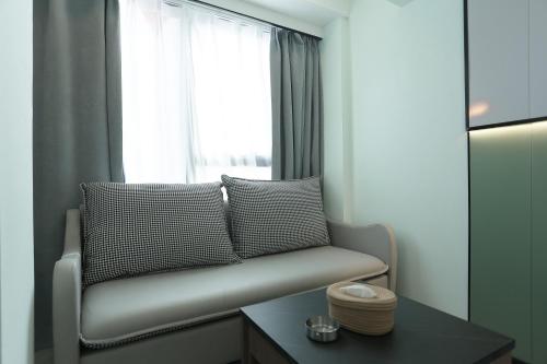 a living room with a couch and a window at Yunbo Youth Hostel Ürümqi in Ürümqi