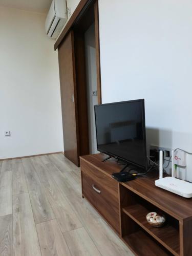 sala de estar con TV de pantalla plana en un centro de entretenimiento de madera en Apartman Banjac, en Trnava