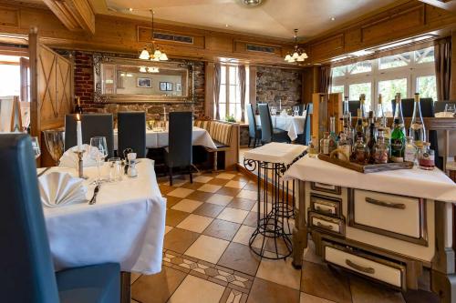 a dining room with two tables and chairs and a restaurant at Landhaus Grum in Hattingen