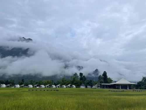 einen Blick auf ein Feld mit Wolken am Himmel in der Unterkunft Family Land Camping Resort in Vang Vieng