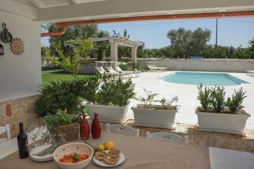 - une table avec un bol de nourriture sur une terrasse avec une piscine dans l'établissement Trulli&Dimore - Casette Pricci, à Castellana Grotte