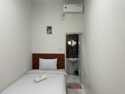 een kleine kamer met 2 bedden en een wastafel bij Cozy Home 2 RedPartner in Manado