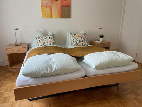 a bed with pillows on it with two night stands at Zentrum Elisabeth in Walchwil