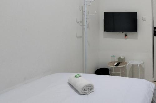 a white room with a bed with a towel on it at Cozy Home 2 Manado RedPartner in Manado