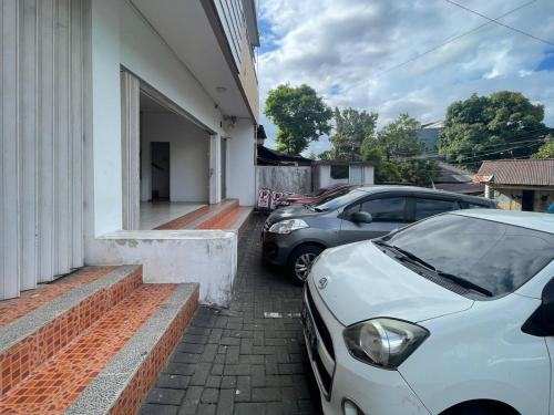 two cars parked in front of a house at Cozy Home 2 Manado RedPartner in Manado