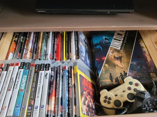 a book shelf with a bunch of video games at Petite maison proche mer - Flamanville in Flamanville