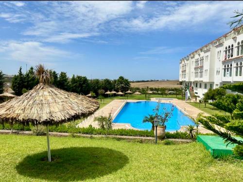 a resort with a swimming pool and a large building at Appartement de vacances piscines et plage in Tangier