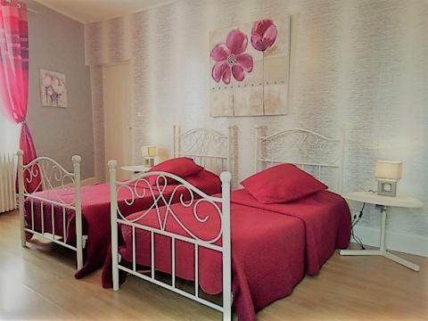 1 dormitorio con 2 camas con sábanas rojas en Chambres et Tables d'Hotes Les Breuils, en Mariol