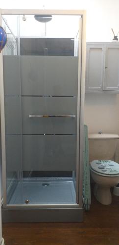 La salle de bains est pourvue d'une douche en verre et de toilettes. dans l'établissement AU 13 : FENETRES SUR ARROMANCHES, à Arromanches-les-Bains