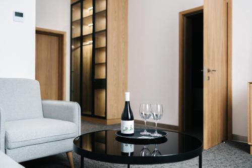 a living room with a bottle of wine and two wine glasses at Old Ijevan Boutique Hotel in Ijevan