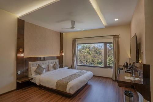 a bedroom with a large bed and a large window at Hotel Stay Casa in Bhopal