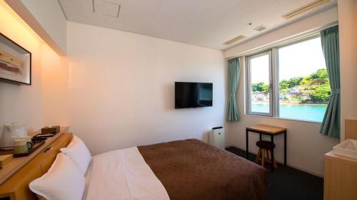 a hotel room with a bed and a large window at urashima INN - GANGI - in Onomichi