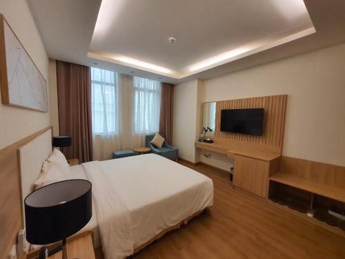 a hotel room with a bed and a flat screen tv at Muong Thanh Holiday Vung Tau Hotel in Vung Tau
