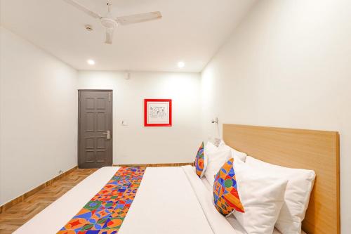 een slaapkamer met een bed met een houten hoofdeinde bij FabHotel Perfect Stays in Chennai