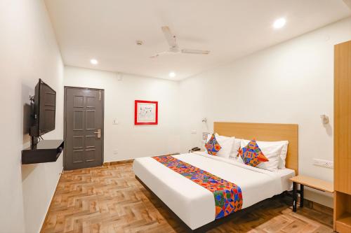 een slaapkamer met een bed en een flatscreen-tv bij FabHotel Perfect Stays in Chennai