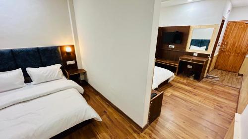 Habitación de hotel con cama y espejo en Hotel Ocean Mountain View, en Manali
