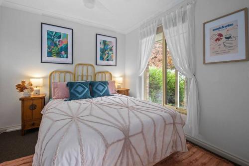 a bedroom with a large bed and a window at Gloria of Healesville in Healesville