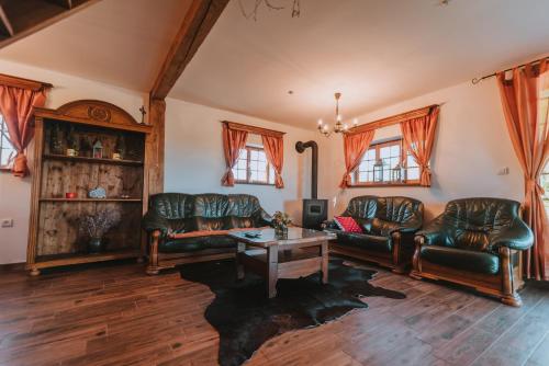 a living room with leather couches and a table at Brunarica Dežno in Makole