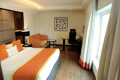 齋浦爾的住宿－齋浦爾巴尼公園公園區酒店，一间卧室配有一张床、一张书桌和一个窗户。
