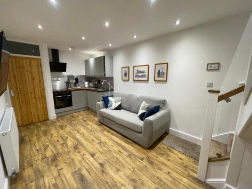 a living room with a couch and a kitchen at The Upton Coach House in Birkenhead