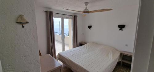 a bedroom with a bed and a ceiling fan at Belvedere de Canaloro in Sari Solenzara