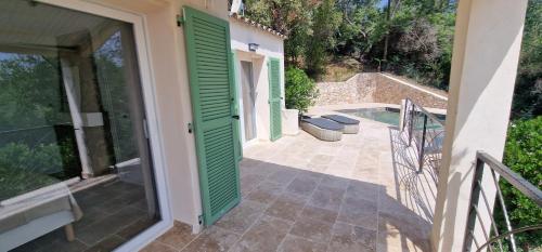 a house with a green door and a patio at Belvedere de Canaloro in Sari Solenzara