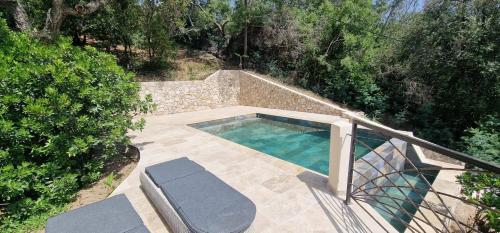 a swimming pool on a patio next to some trees at Belvedere de Canaloro in Sari Solenzara