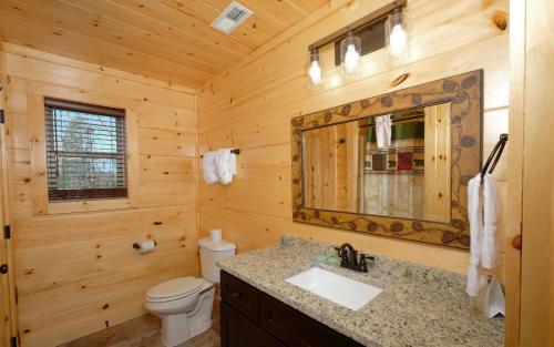 uma casa de banho em madeira com um lavatório e um WC em Wine Down em Gatlinburg