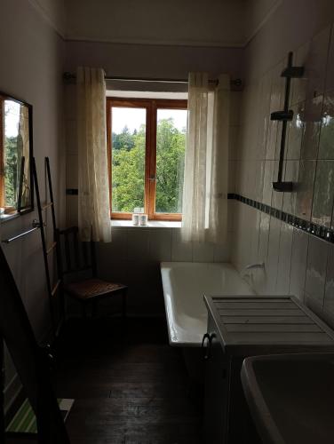 une salle de bain avec une baignoire et une fenêtre dans l'établissement Maison de charme au calme, à Nedde