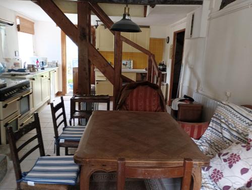 une cuisine avec une table et des chaises dans une pièce dans l'établissement Maison de charme au calme, à Nedde