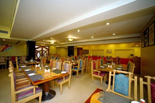 un restaurante con mesas y sillas en una habitación en Raj Park- Hill View, en Tirupati