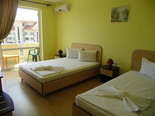 sypialnia z 2 łóżkami i oknem z widokiem w obiekcie Anelia Family Hotel w mieście Kawarna