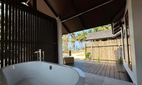 uma banheira na casa de banho com um deque em Chumphon Cabana Resort em Chumphon