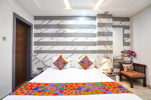 a bedroom with a large bed with a colorful blanket at FabHotel Prime Mansa in Kānpur