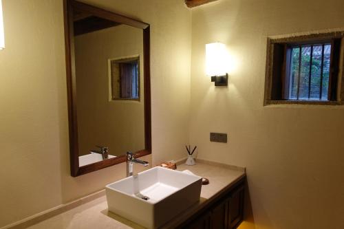 a bathroom with a sink and a mirror at Sanhe Daoli Resort in Qingyuan