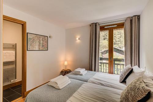 sypialnia z łóżkiem i oknem w obiekcie Les Melées Apartments - Alpes Travel - Argentiere w Chamonix-Mont-Blanc