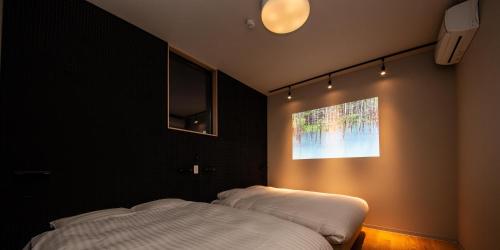 a bedroom with a bed and a picture on the wall at Rakuten STAY MOTEL Nikko Kinugawa in Nikko