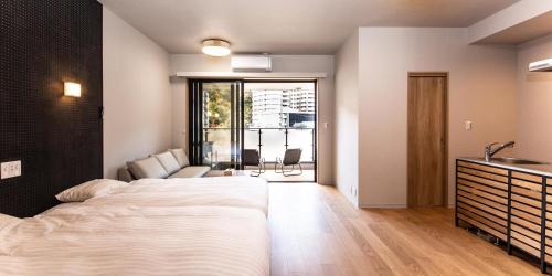 a bedroom with a large white bed and a bathroom at Rakuten STAY MOTEL Nikko Kinugawa in Nikko