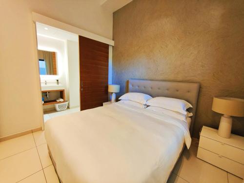 a bedroom with a large white bed in a room at Apartment in a Tropical Oasis, Ki Residences, Pereybere - Managed by KSN in Pereybere